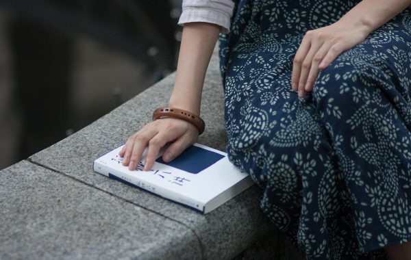 日系清新人像壁纸，少女坐在窗边捧书阅读，柔和自然光从窗帘透入，浅景深背景虚化，温柔静谧